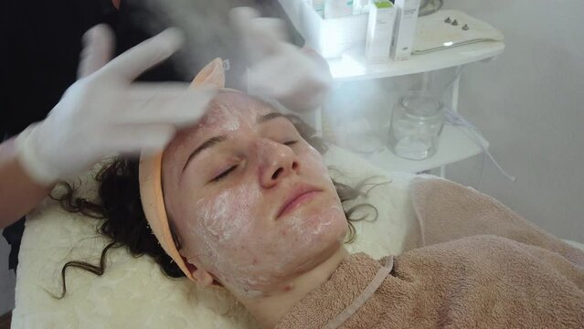 Acne treatment of problematic face skin with ozone facial steamer in spa or dermatology center. Steam for smooth skin and open pores before applying face mask