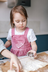 Fototapeta premium Lifestyle photo of cooking Easter decor. Family time. Under celebrated moment. Little girl making cookies. Close-up.
