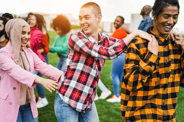 Young diverse people having fun outdoor dancing together - Focus on bald girl face