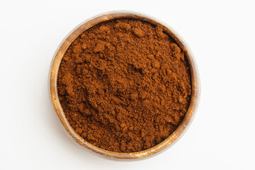 Ground coffee in wooden bowl isolated on white background