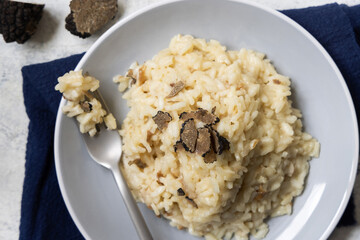 Risotto with porcini mushrooms and black truffles served in a plate top view, gourmet cousine
