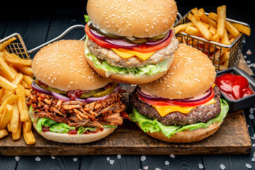 Set of different burgers with french fries . Burger with chicken, beef and smoked pork