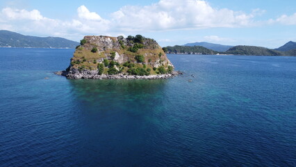 Small tropical island in the middle of the sea. Aerial view of an island in the ocean.