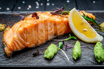 Grilled salmon and spices on stone plate. Top view