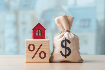 Money bag with Dollar sign and house on cube with percent sign. Concept of real estate price, mortgage, rent and house buying