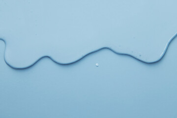 Flowing gel surface smudges transparent cosmetic background. Blue color