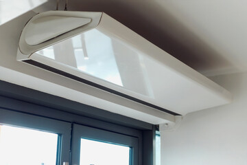 Heat Screen Electric Air Curtain in door public office building. Automatic heating fan top over...