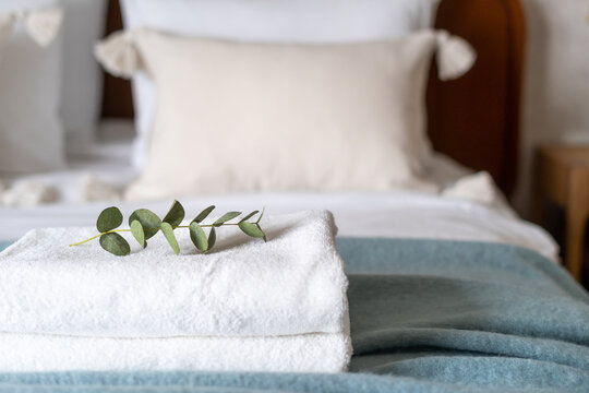 clean folded bath towels on bed in hotel room, closeup