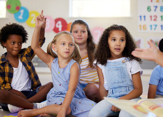 Teacher, hands up or kids in classroom learning, test or studying with preschool story books. Development or smart children or young students with answers, ideas or knowledge in kindergarten creche