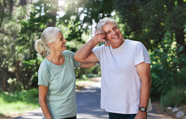 Obraz premium Senior couple, exercise and laugh outdoor for run, workout and training on road for fitness. Old man and woman happy and tired of cardio for health and wellness while running in nature in retirement