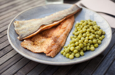 Appetizing baked trout fillets with green peas