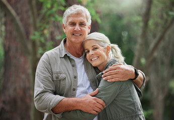 Hug, hiking and portrait of senior couple with smile on adventure in forest, woods and mountain for exercise. Fitness, travel and happy elderly man and woman in retirement, holiday and relax on hike