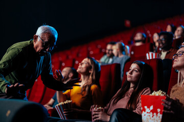 Senior man walking in movie theater.