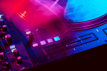 Close up of DJ mixing console in party light