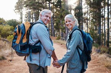 Love, hiking and portrait of old couple holding hands on nature walk in mountain forest in Canada....