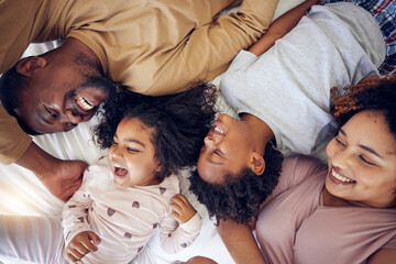 Happy, above and family laughing in bed, smile and bonding while resting in their home. Top view, smile and children waking up with mother and father in a bedroom, playful and having fun