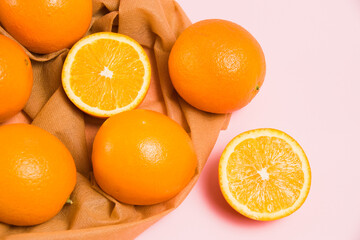 Juicy oranges in a reusable bag for fruits and vegetables on a pink background. Concept of earth day, zero waste and recycling.