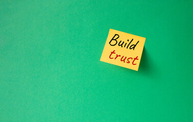 Build trust symbol. Orange steaky note with words Build trust. Beautiful green background. Business and Build trust concept. Copy space.