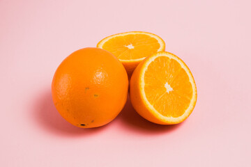 Juicy pieces of orange on a pink background. Delicious fruit on a bright background.