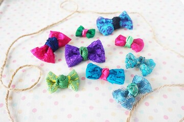Colorful bow tie on white fabric with polka dot background.