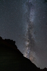 Milky way over the dark black mountain