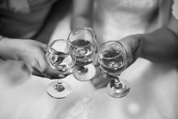 Black and white photo of three girls clinking glasses of champagne