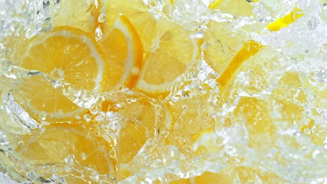 Super Slow Motion Shot of Fresh Lemon Slices Falling into Water Whirl on Light Background at 1000fps