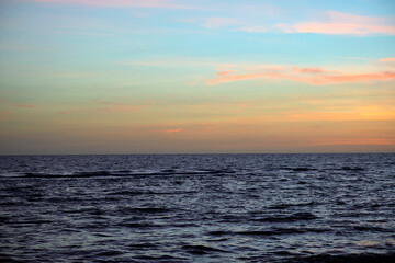 Naklejka premium Dramatic red ocean waves at sunset with soft evening sea dark water