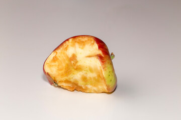 Half eaten old apple against a white background