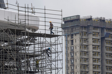 Fototapeta premium 2023 Mar 29,Hong Kong.Workers working on scaffolding of building