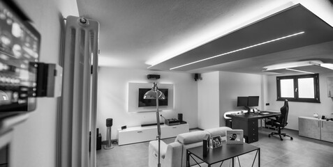 Moving to a new house. House interior. Ideas for basement living room. Entertainment room with TV and color led strips