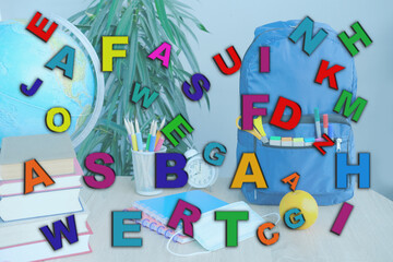 scattering of multi-colored different letters against school stuff background, speech disorders, dyslexia awareness, help children with reading, learning difficulties, human brain development concept