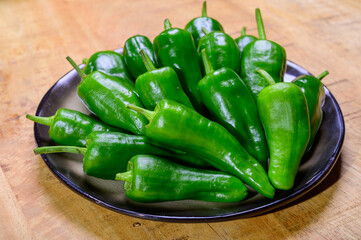 Fresh green mild padron pepper pementos, ready for grill or to be fried with olive oil, traditional snack in Galicia, Spain