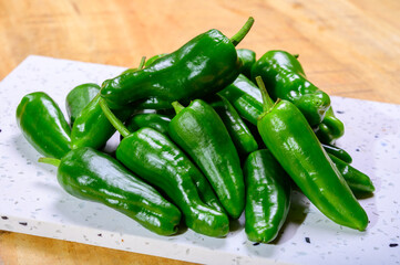 Fresh green mild padron pepper pementos, ready for grill or to be fried with olive oil, traditional snack in Galicia, Spain
