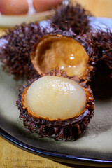 Tasty tropical exotic fruits, ripe fresh peeled and unpeeled hairy rambutan southeast Asian fruits  rambutan southeast Asian fruits