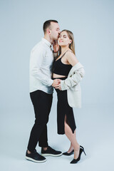 Beautiful young couple in love hugging on a white background. A stylish couple embraces and enjoys feelings. Men and women in stylish casual clothes