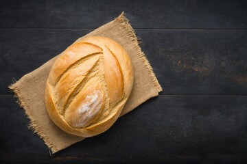 baked bread, delicious freshly baked bread resting on top of a tea towel on a black wooden table