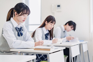 集中してノートを取る高校生