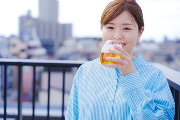 屋外でビールを飲む若い女性