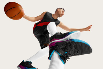 Portrait of athletic male basketball player training over white background