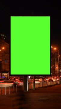 Vertical Screen: timelapse of green screen billboard with night traffic. lightbox with chroma key on city street at night . Concept commercial public information and advertising marketing