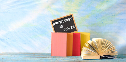 education,learning,knowledge concept,books, open book and blackboard with slogan knowledge is...