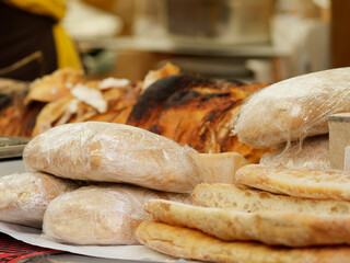 Sourdough bread close-up. Freshly baked round bread with a golden crust on bakery shelves. German baker shop context with rustic bread assortment.