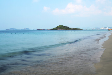 The concept of a summer holiday at sea. The line of the sandy sea shore. Yellow sand, turquoise blue sea.
