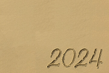 Fototapeta na wymiar Inscription 2024 on the sand