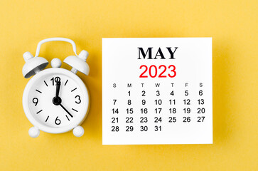 The May 2023 Monthly calendar for 2023 year with alarm clock on yellow background.
