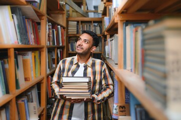 Happy smart indian or arabian guy, mixed race male, university student, in the library