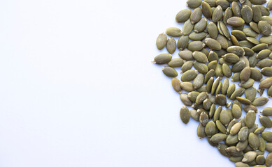 pumpkin seeds on white background, healthy food and nutrition concept