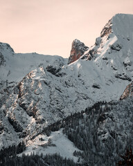 New snow in rocky mountains at a beautiful winter sunset scenery with high peaks.