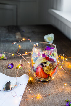 modern trifle dessert in a glass with copper wire fairy lights